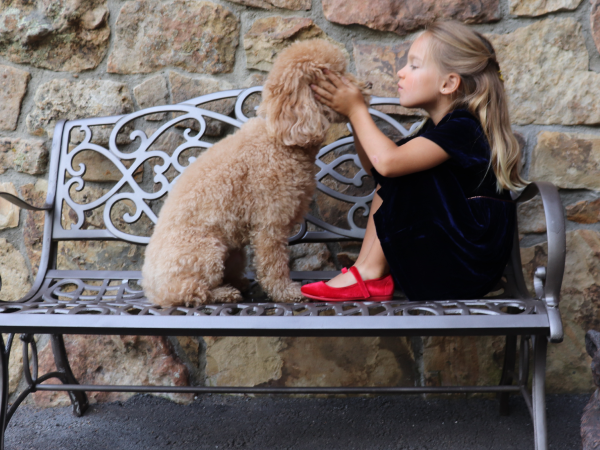 Girl playing with a dog wearing mary jane shoes