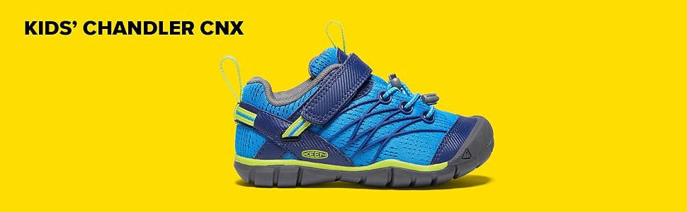 a dark and light blue childrens chandler cnx sneaker with lime accents on a yellow background.