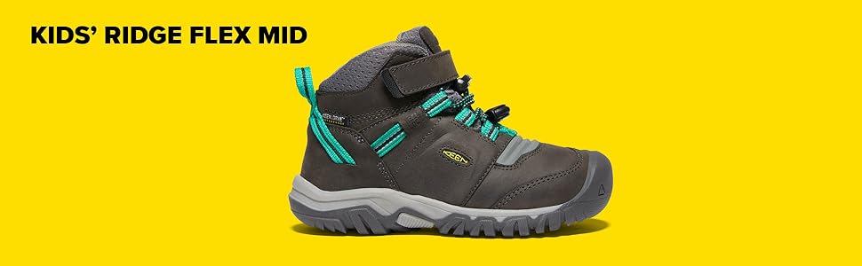 A grey mid height hiking boot for kids with teal accents and KEEN.Bellows Flex in the foretoe.