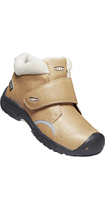 A mid height tan kootenay 3 boot with white faux fur sticking out of the top and a black sole.